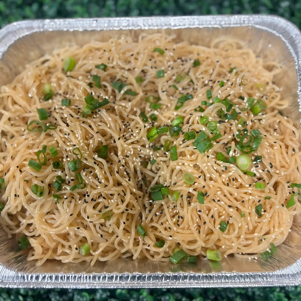 Healthy noodles with sesame seeds and green onions in a foil container from Fork 'N' Bowl.